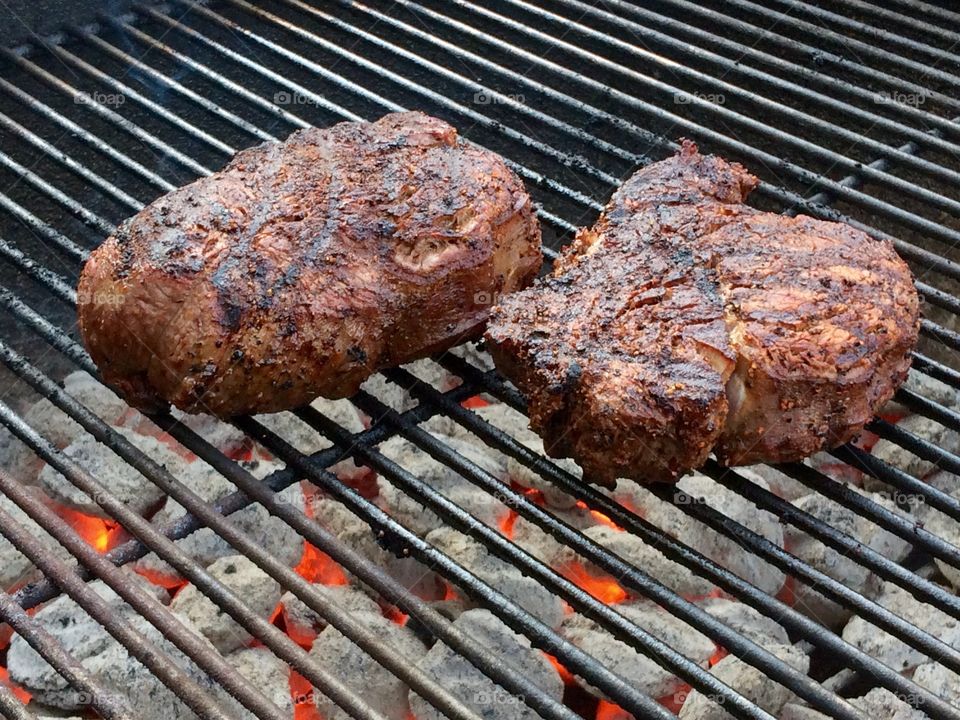 Beef tenderloin fillets grilling over glowing Kingsford briquettes. 