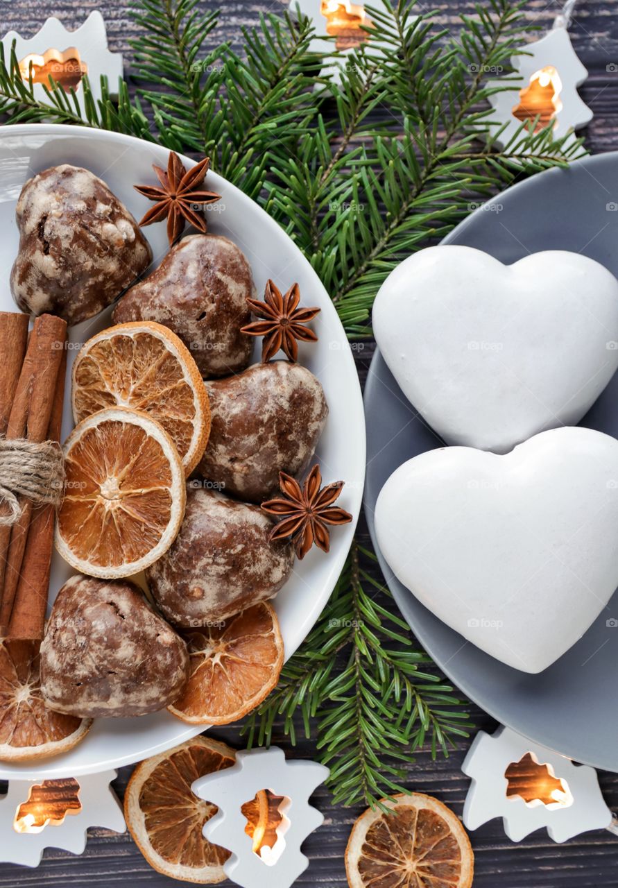 Gingerbread cookies in plates with dried orange rings, anise and Christmas tree branches