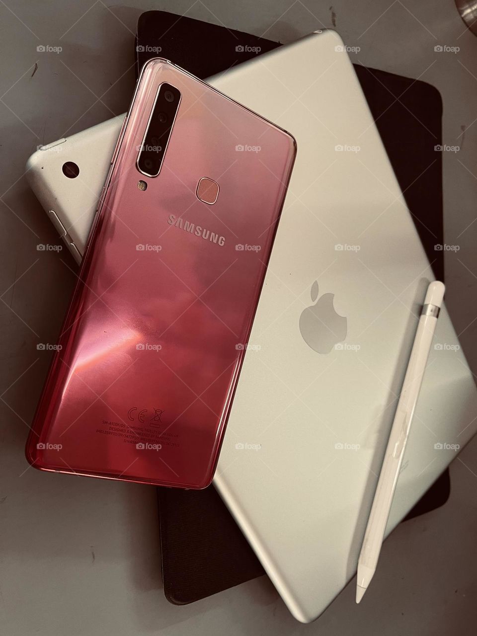 Samsung smartphone and iPad with Apple pencil, devices nowadays use for work and learning.