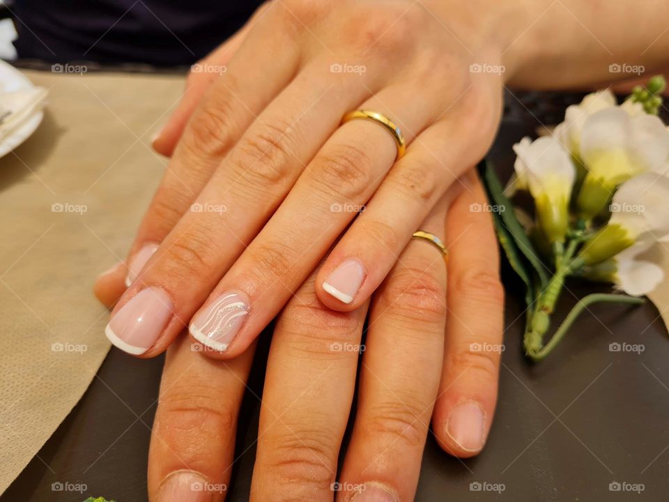 hands of two newlyweds on each other