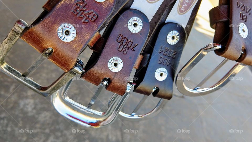 Cintos de couro. Com fivelas, códigos e numeração de tamanhos, medidas.