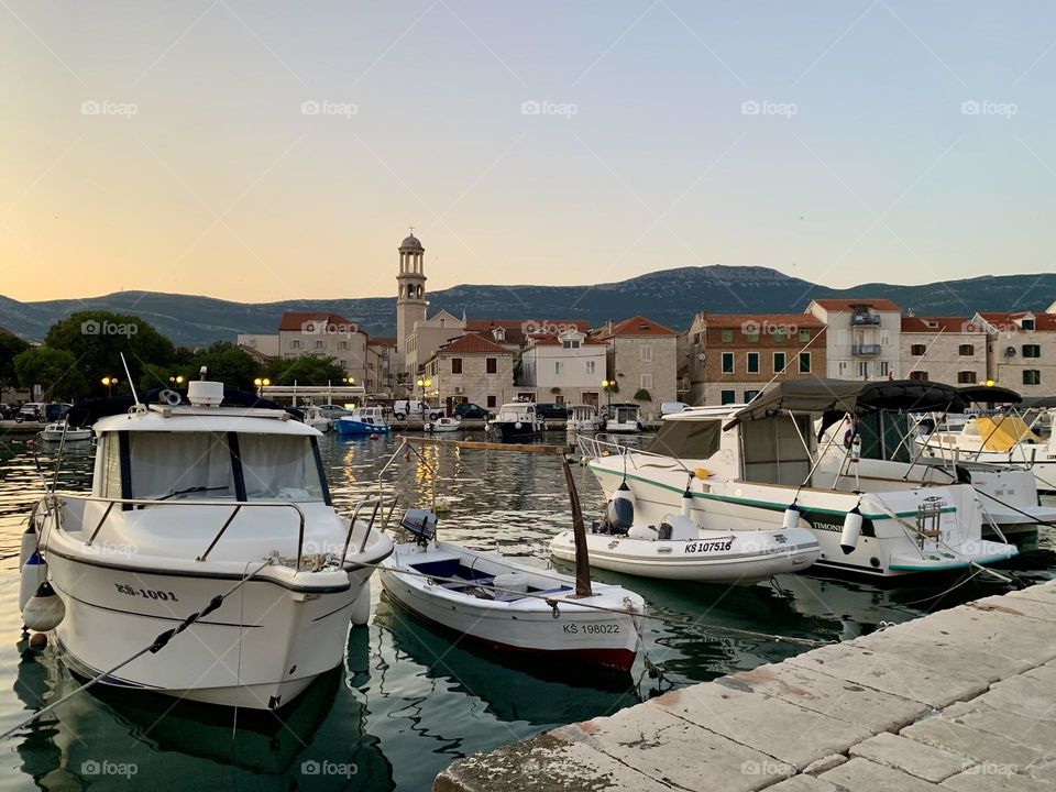 sea ​​pier of boats on the background of the old town and mountains, Europe