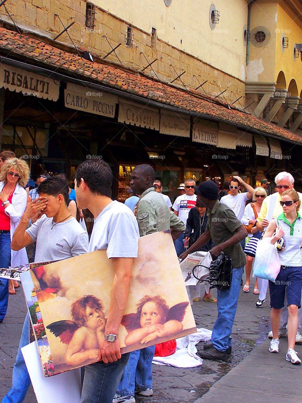 Man selling oil paintings on a crowded street in Italy