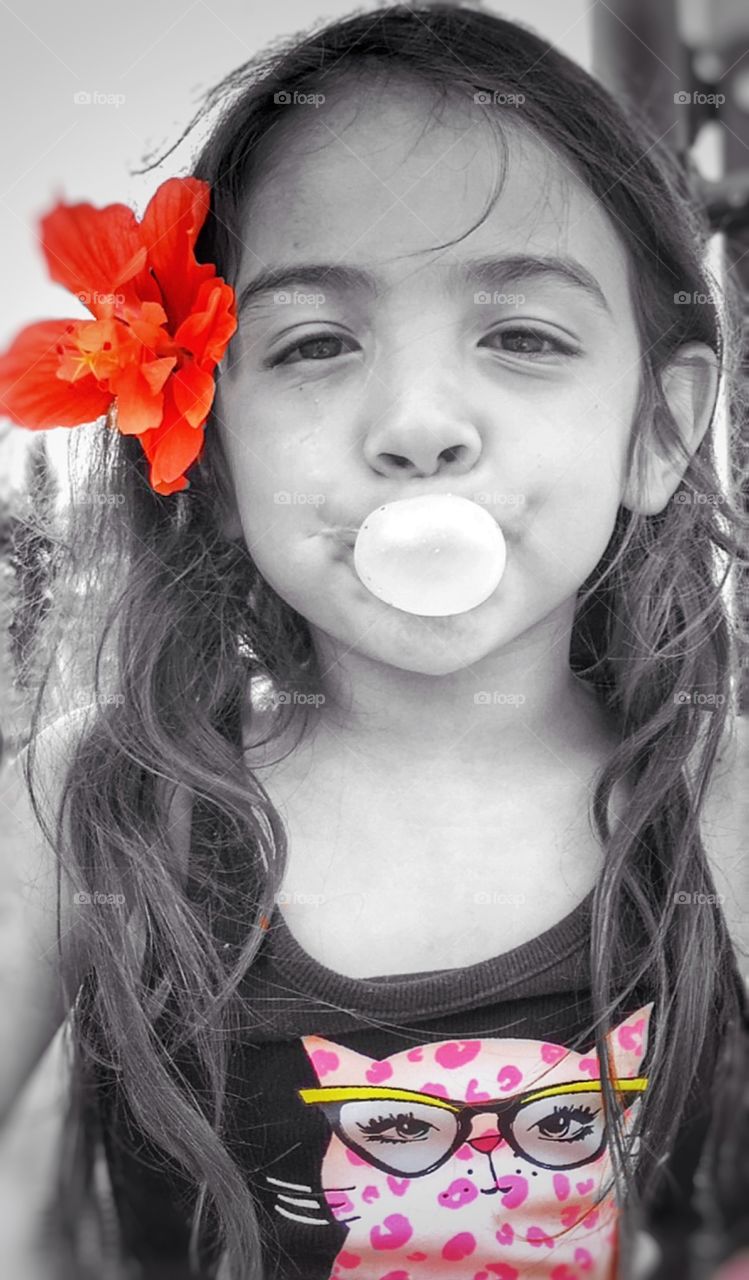 Little girl blowing a bubble