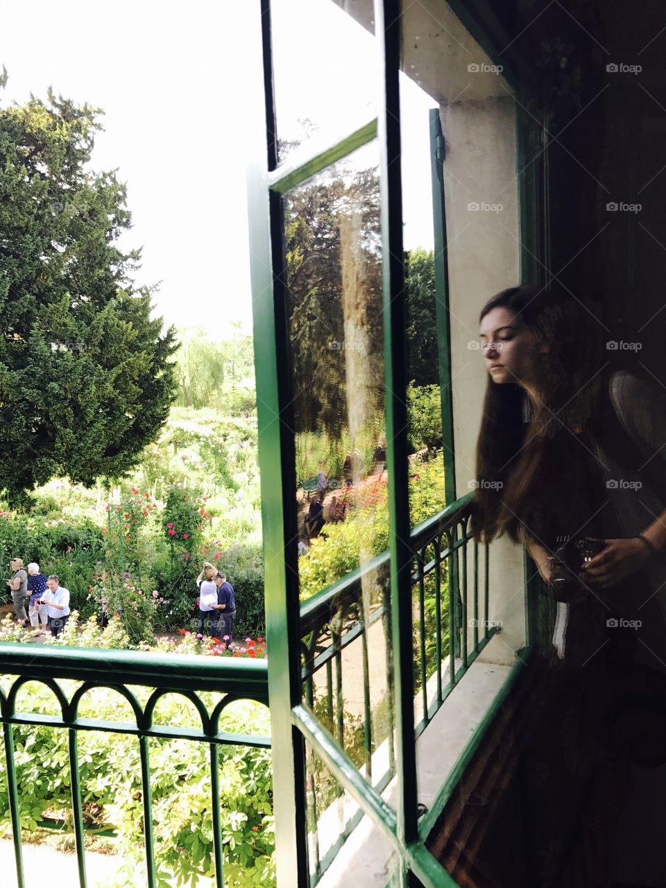 Woman standing near window with camera