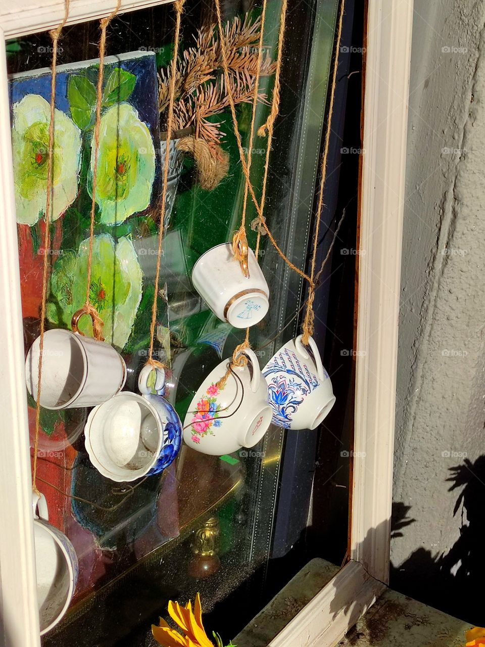 Gift shop window.  Cups hang on a rope on the outside of the window