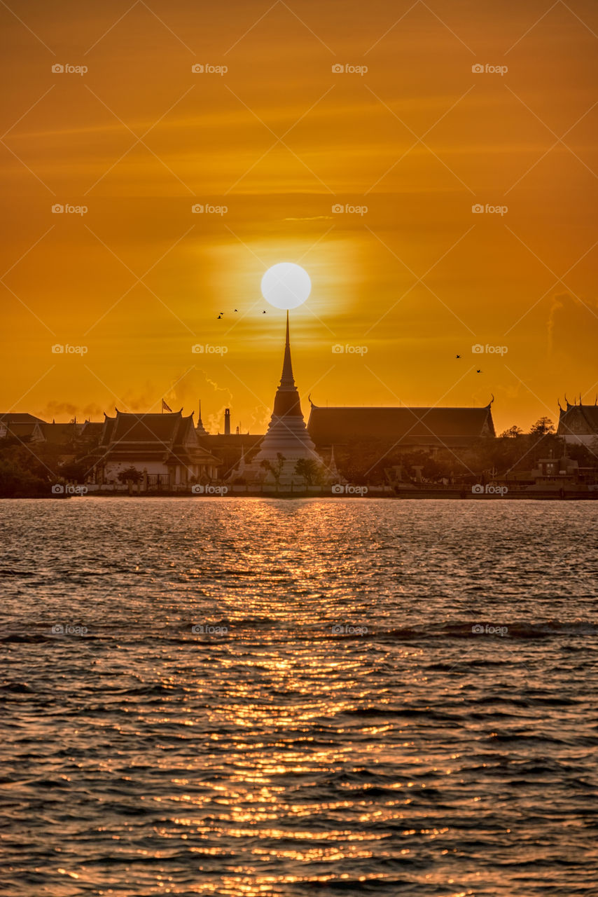 Golden sunset scene above Thai pagoda