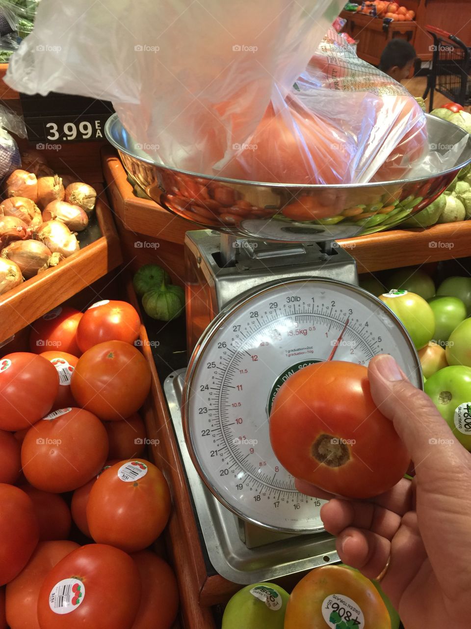 Vegetables. Man selecting tomatoes in super market