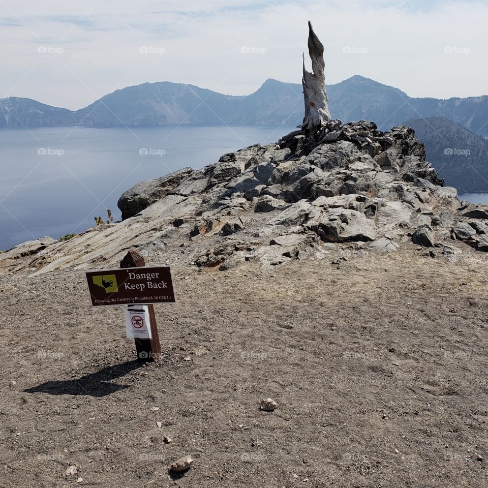 A sign on the rim of Crater Lake warns of the danger of the rocky cliff. 