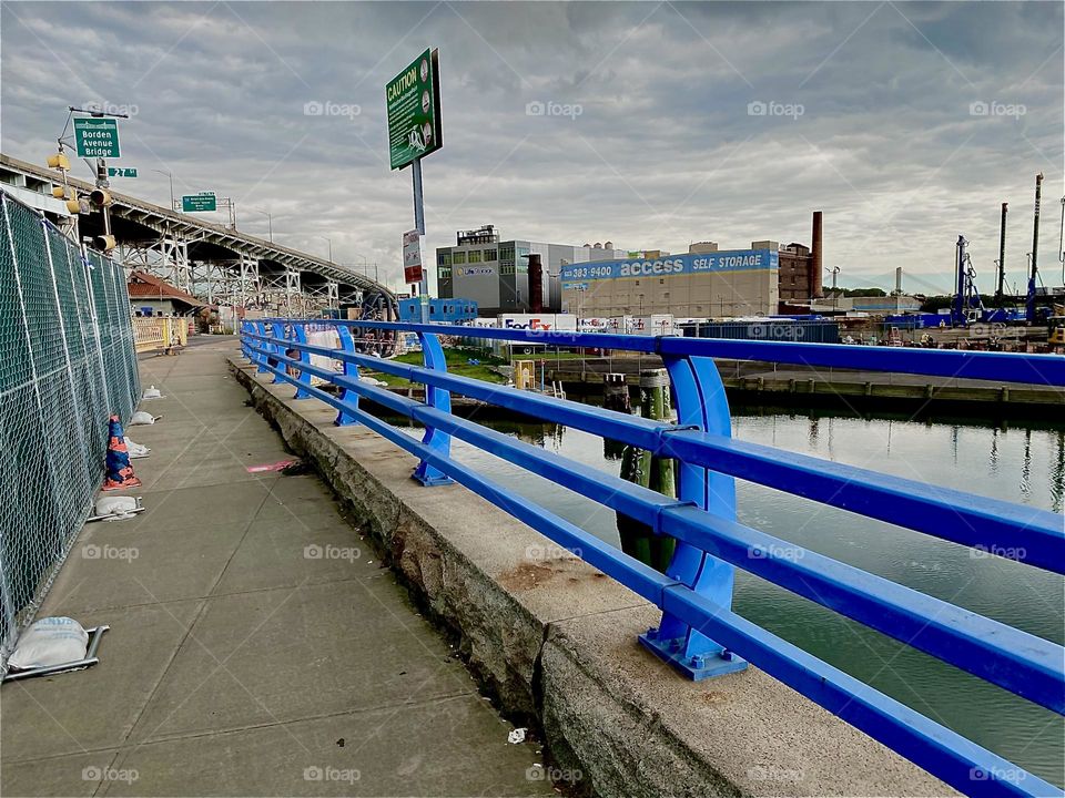 This is the „Borden Ave Bridge“ over „Dutch Kills“, an ocean inlet of the „E River“ similar to „Newtown Creek“ by the „Pulaski Bridge“ in LIC, Queens. Apparently merging are its railing and the „Brooklyn Queens Expressway“. 2023. Hypnotic Productions