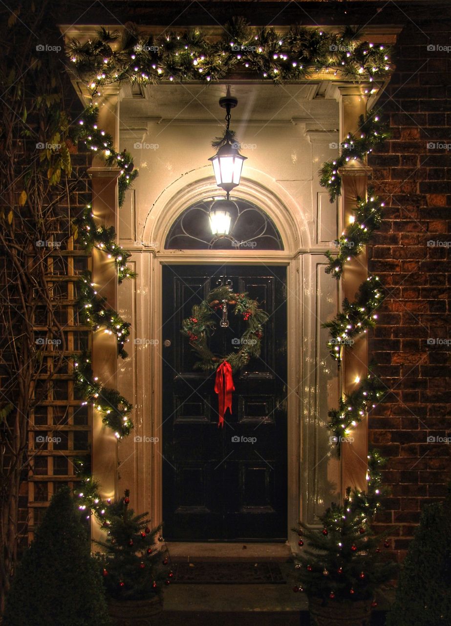 Christmas Door and Wreath. A traditional Christmas scene of an old fashioned door with Xmas lights and wreath.