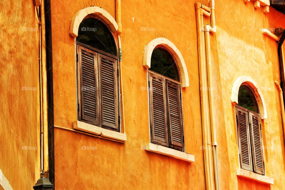 Classic and beautiful 3-bay wooden windows on the walls painted in orange.  Looks very beautiful.