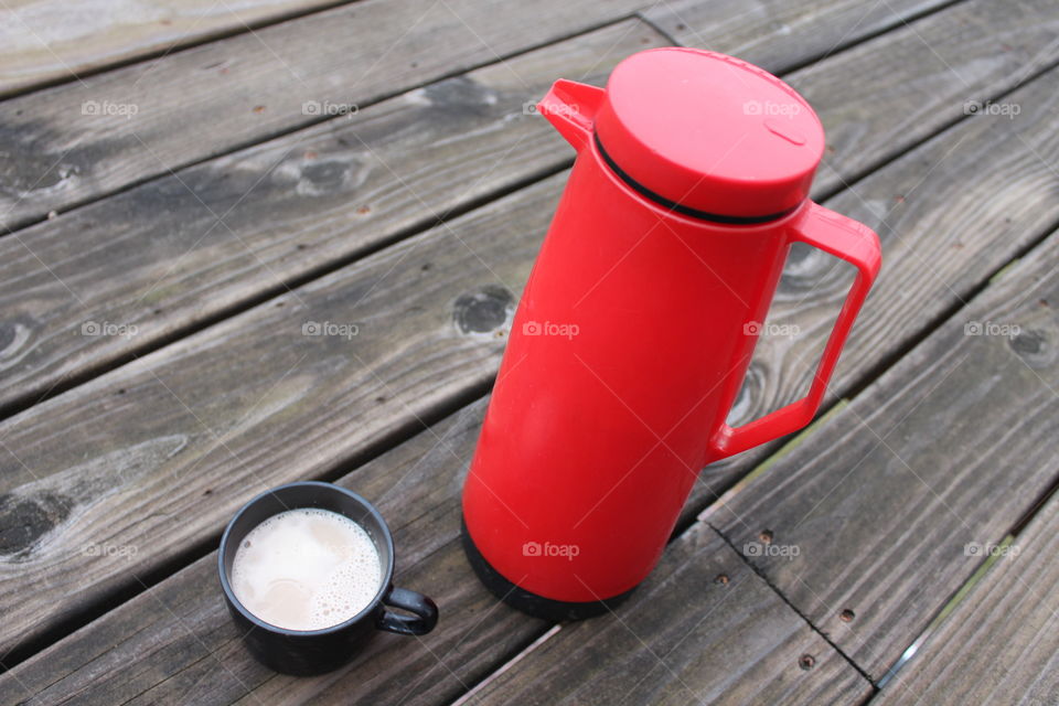 Red flask and coffee cup on wood