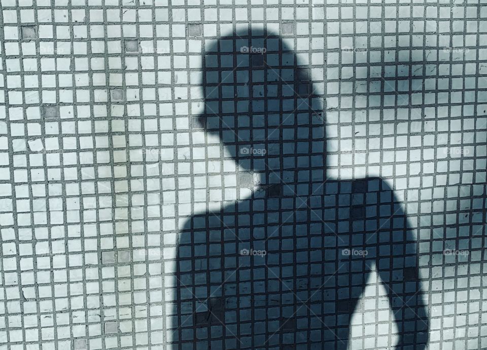 Female shadow at tile bricks wall 