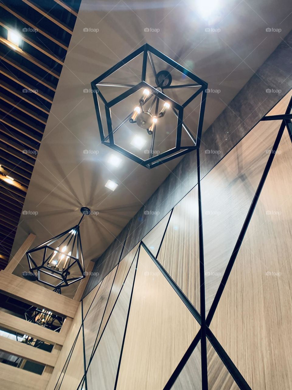 Lights on hexagonal design and triangular wood wall inside the restaurant in New York.
