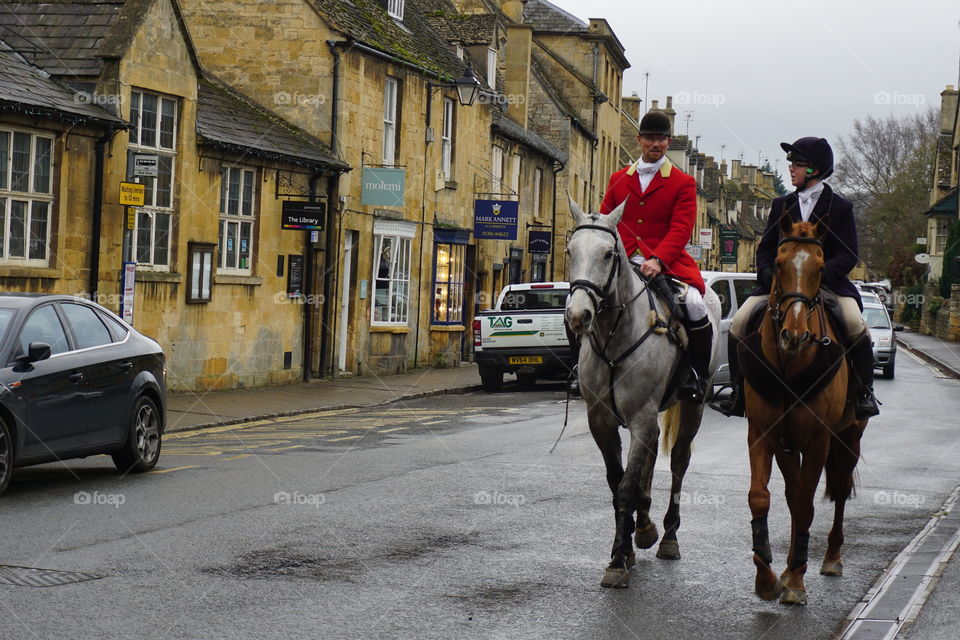 Returning from the hunt .. horsemen riding through a Cotswold Village 