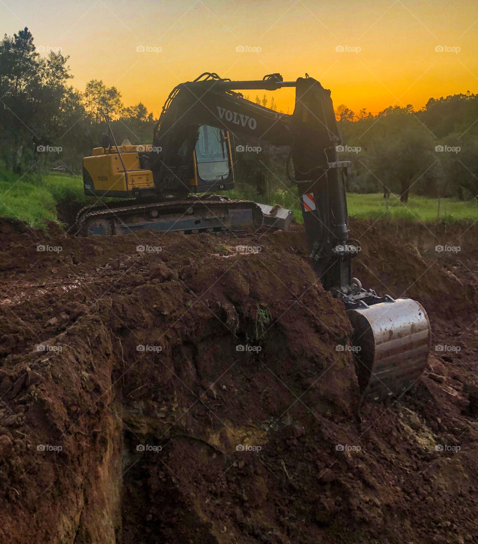 Volvo hydraulic excavator, seen with a countryside setting at sunset