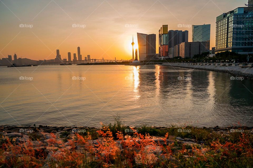 Sunset behind the structures along city coastline