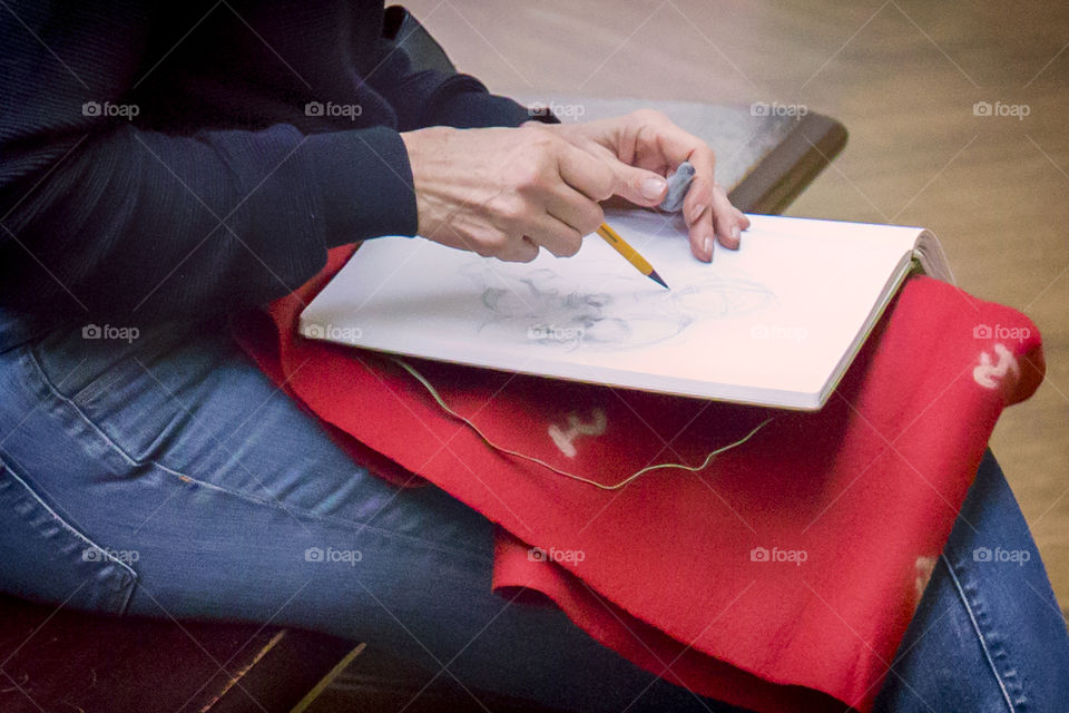 Close up of hands of female artist working with pencil sketch 