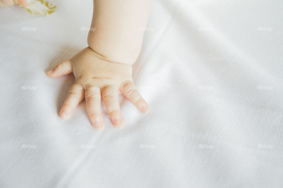 Closeup of baby's hand on white cloth