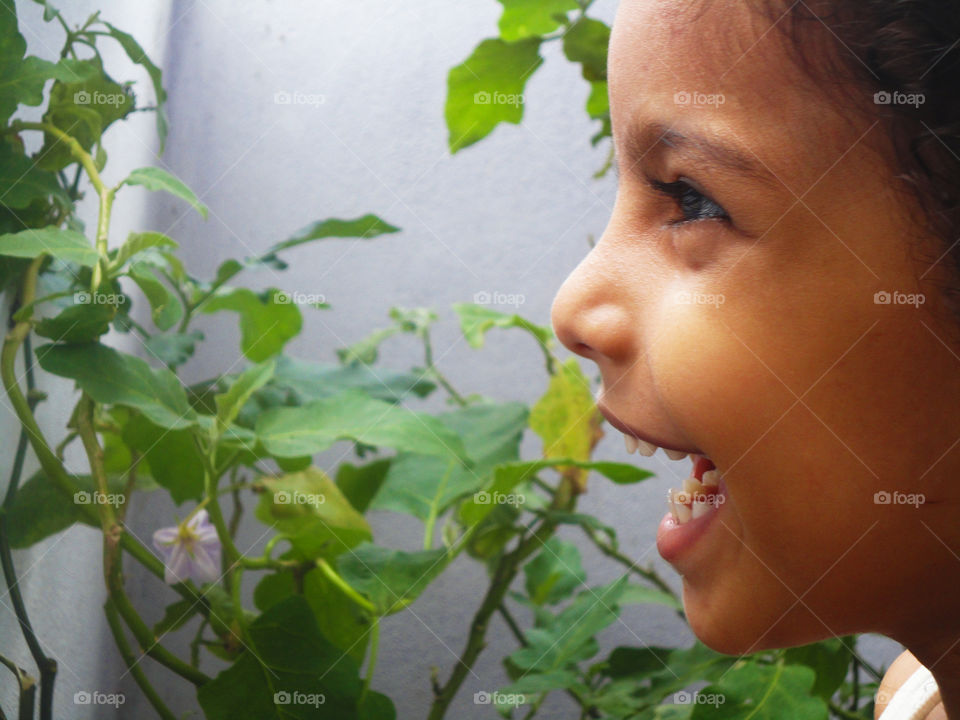 Close-up of a happy girl near flower plant
