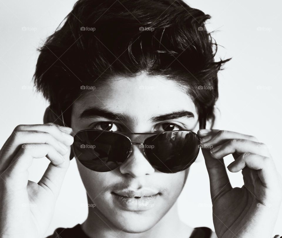 portrait of a young boy with sunglasses. black and white