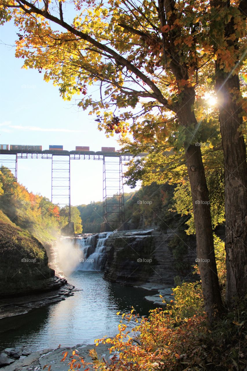 Train in sun over falls