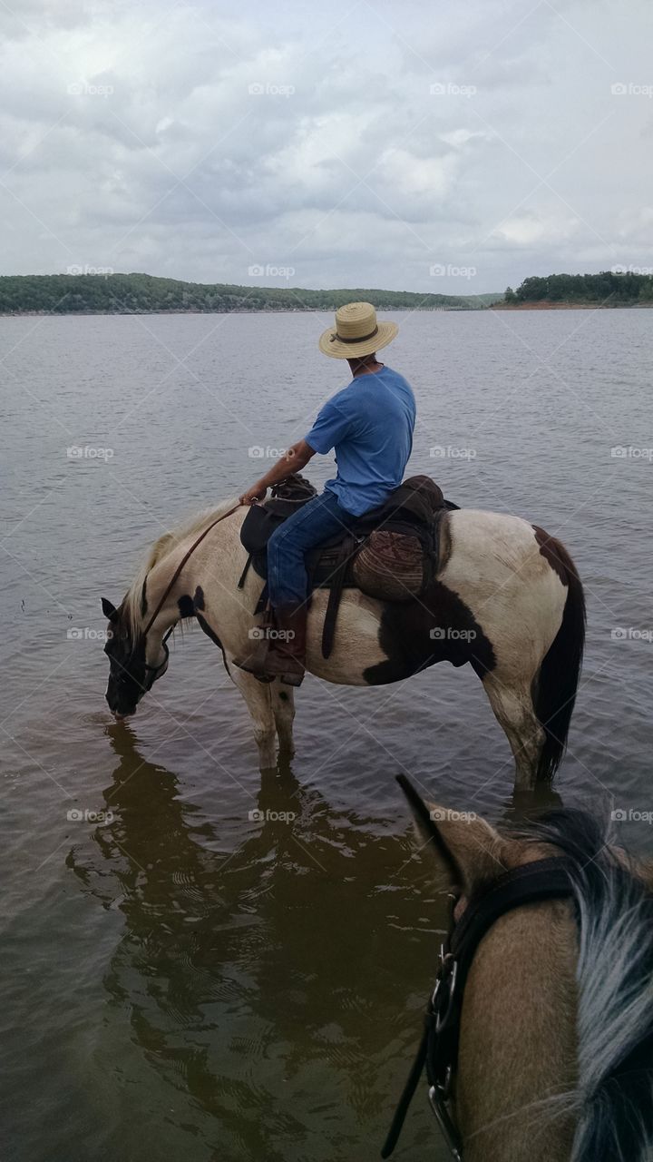 cowboy and his horse taking a drink break