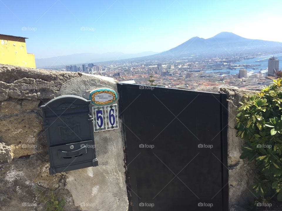 Italian gate with a mailbox, in front of a great and sunny view of mount Vesuvius. 