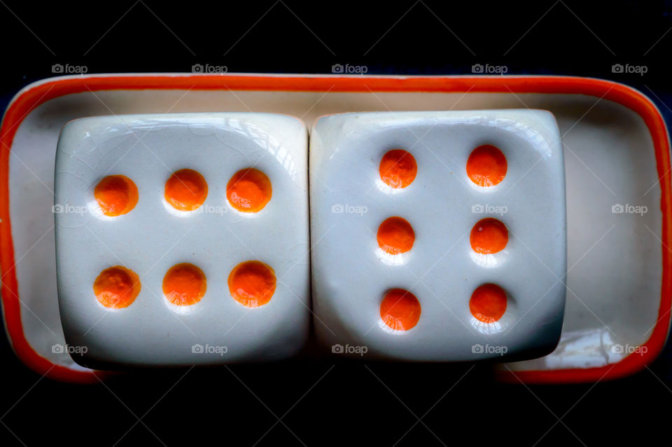 Selective focus on dices: Casino cube dice set. Number 6 gambling dices or red gaming dices on black background. Room for text. Game object or parlor gaming concept.