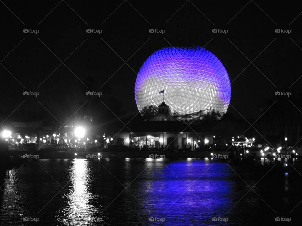 The reflection of Spaceship Earth reaches out onto the surface of the World Showcase lagoon.