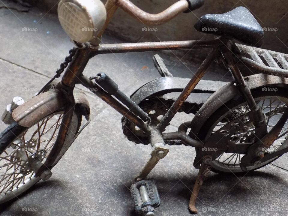 Old, rusty and broken toy bicycle