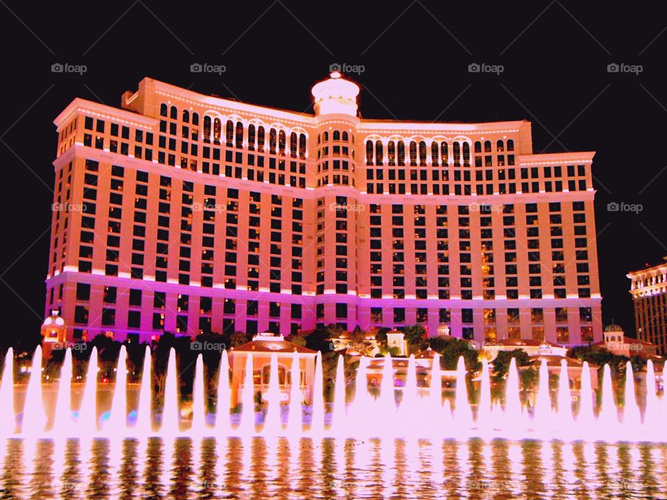 Bellagio and fountains with pink light reflection