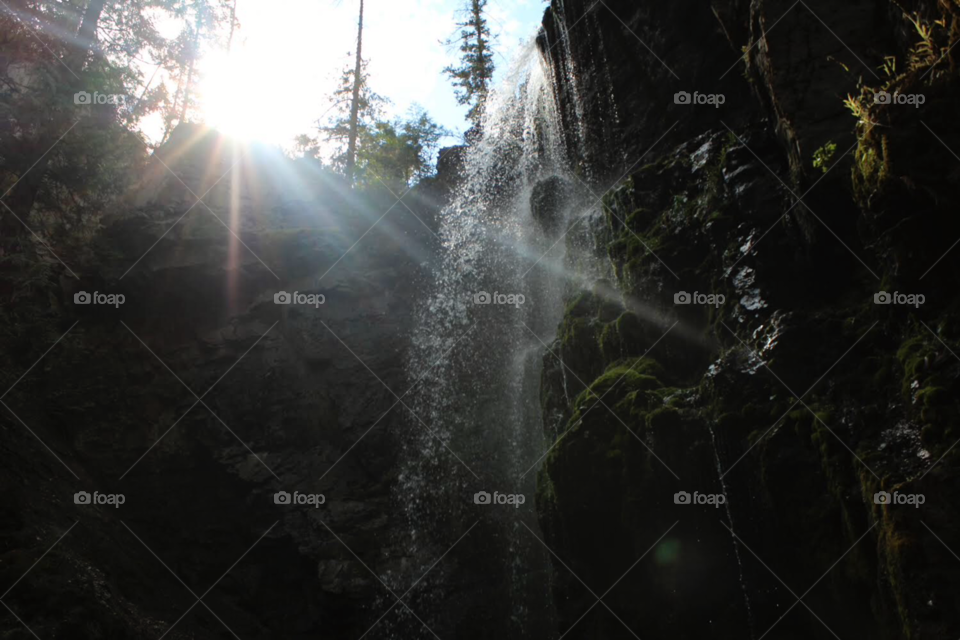 Rays of sunshine being casted on a water fall in British Columbia 