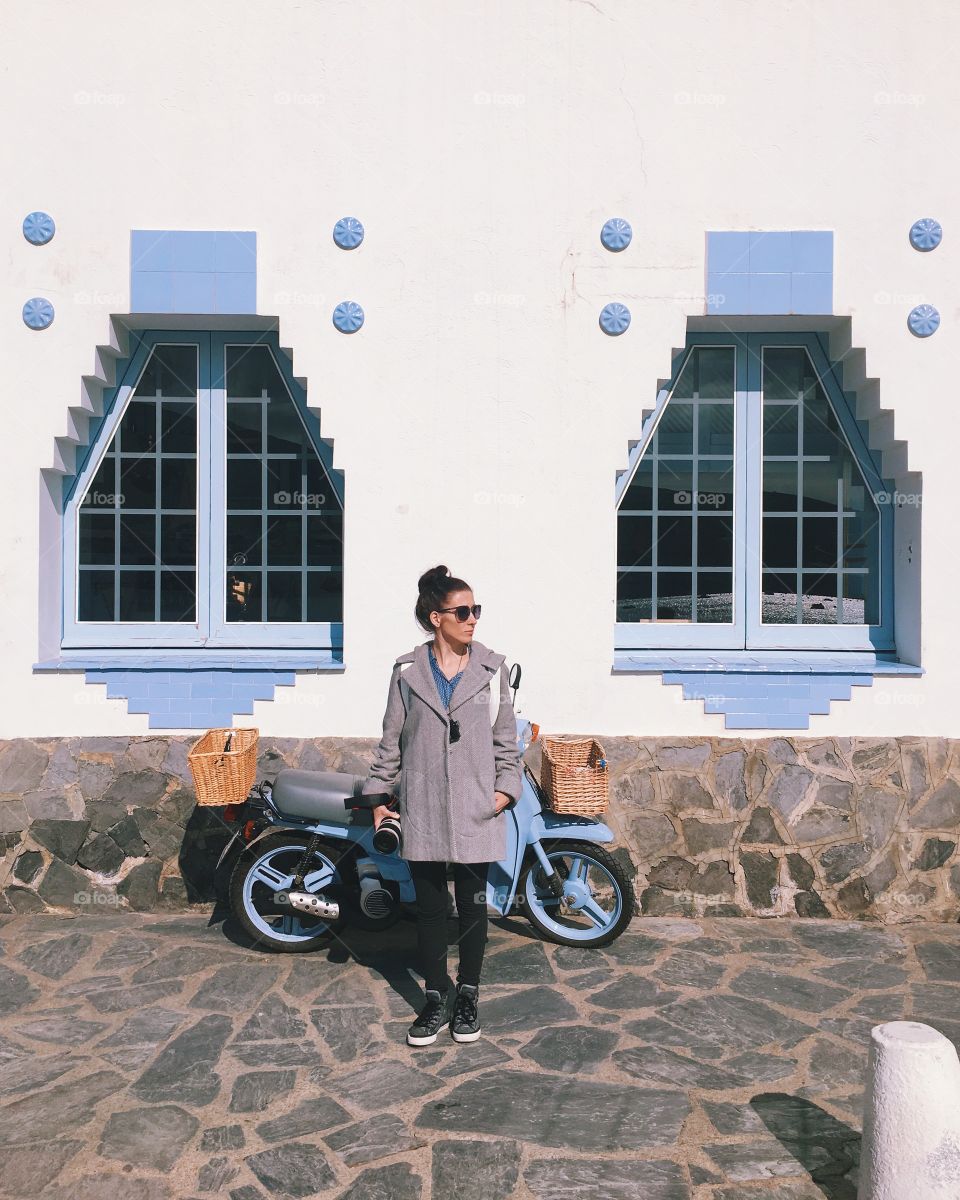 A woman standing next to the motorcycle