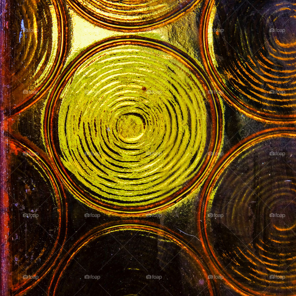 yellow stained glass window with circular patterns