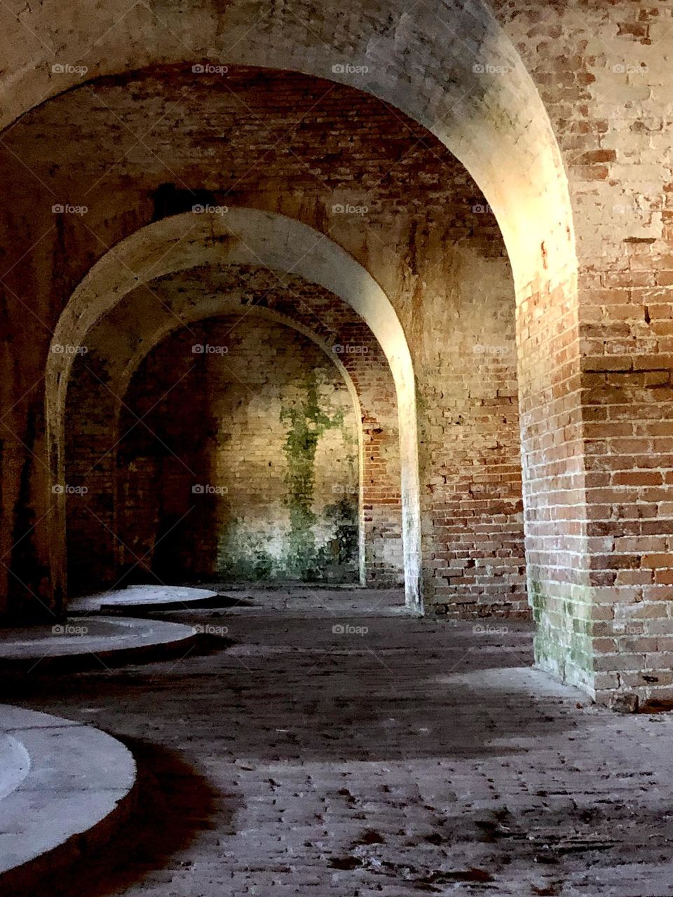 View into old fortress. The brick arches continue into the shadows.