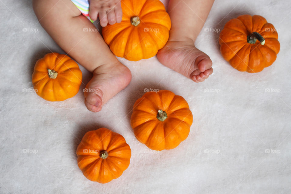 baby plaing with pumpkins