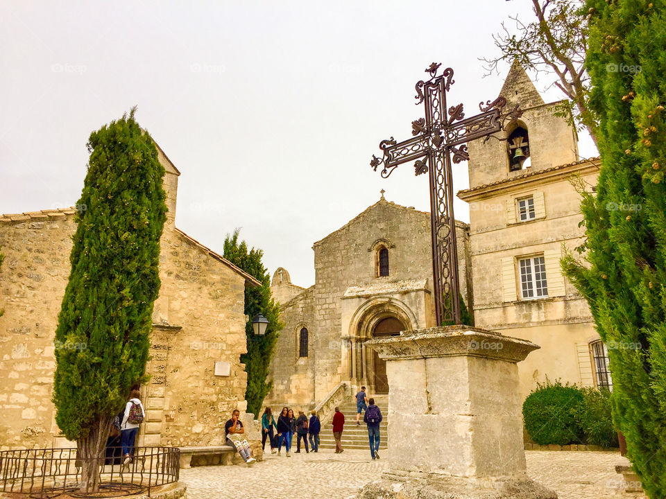 Church and cross in plaza in hilltop ancient village in France