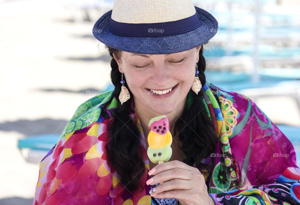 Colorful outfit of smiling woman holds an icecream