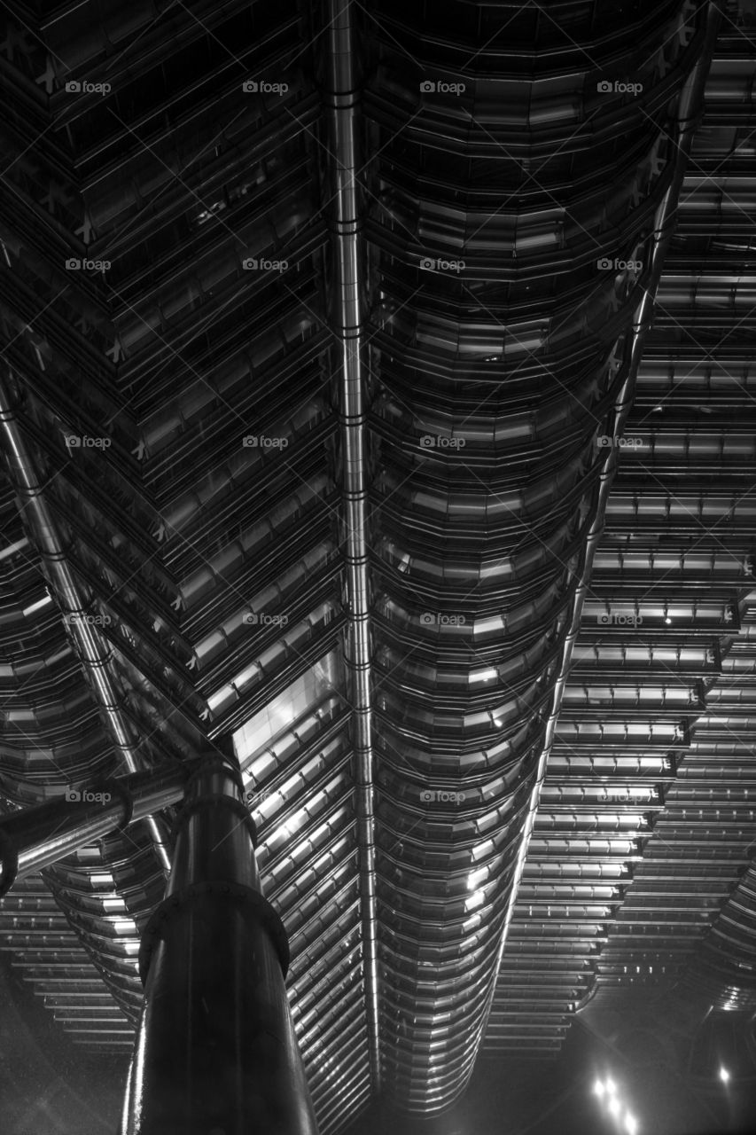 Vertical view from Petronas. Vertical view from Petronas tower during rain storm. Spotlights reflect from the Windows. Observation deck support beam