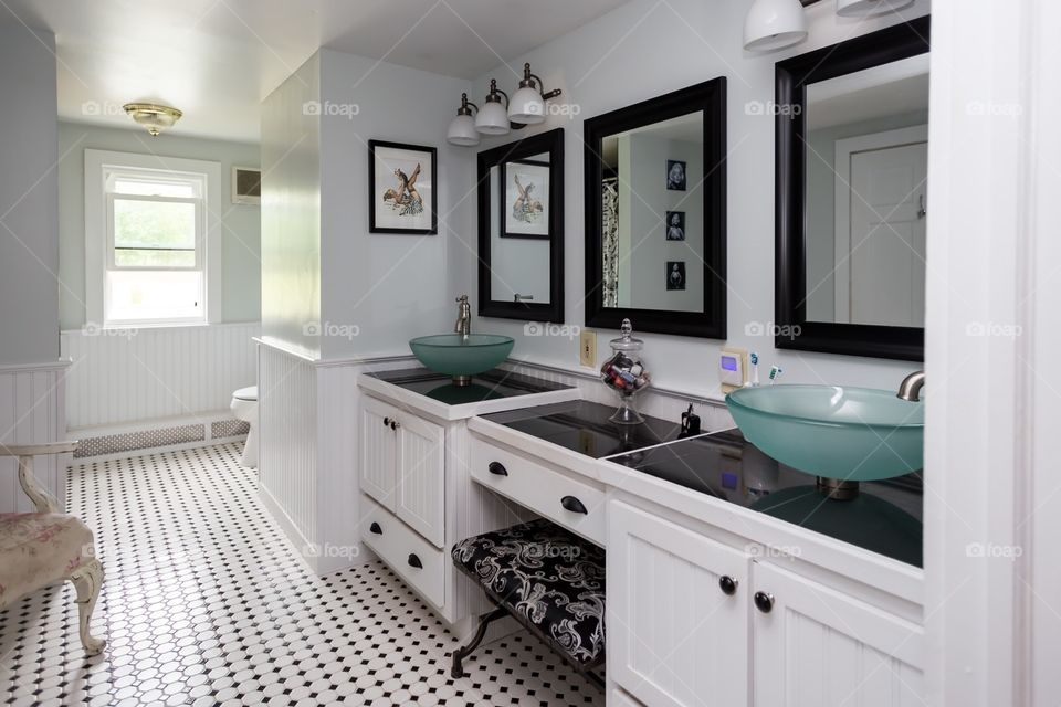Bathroom inspiration with black granite tops, white bathroom vanity , three black frame mirrors, Two contemporary bathroom sink bowls, black and white theme, vanity stool, very contemporary with modern touches 
