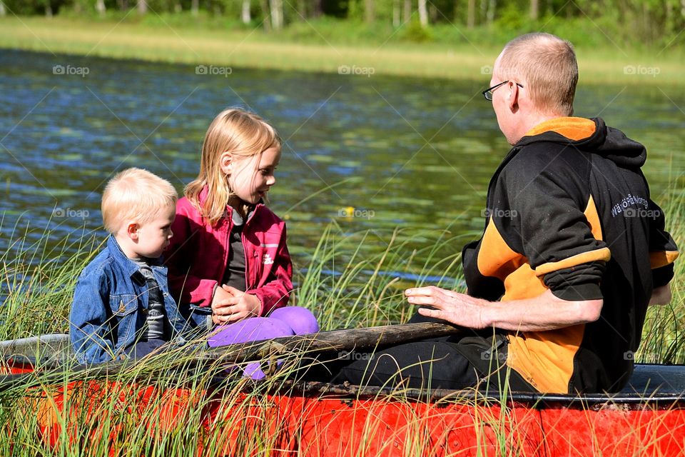 Children with father on boat at lake