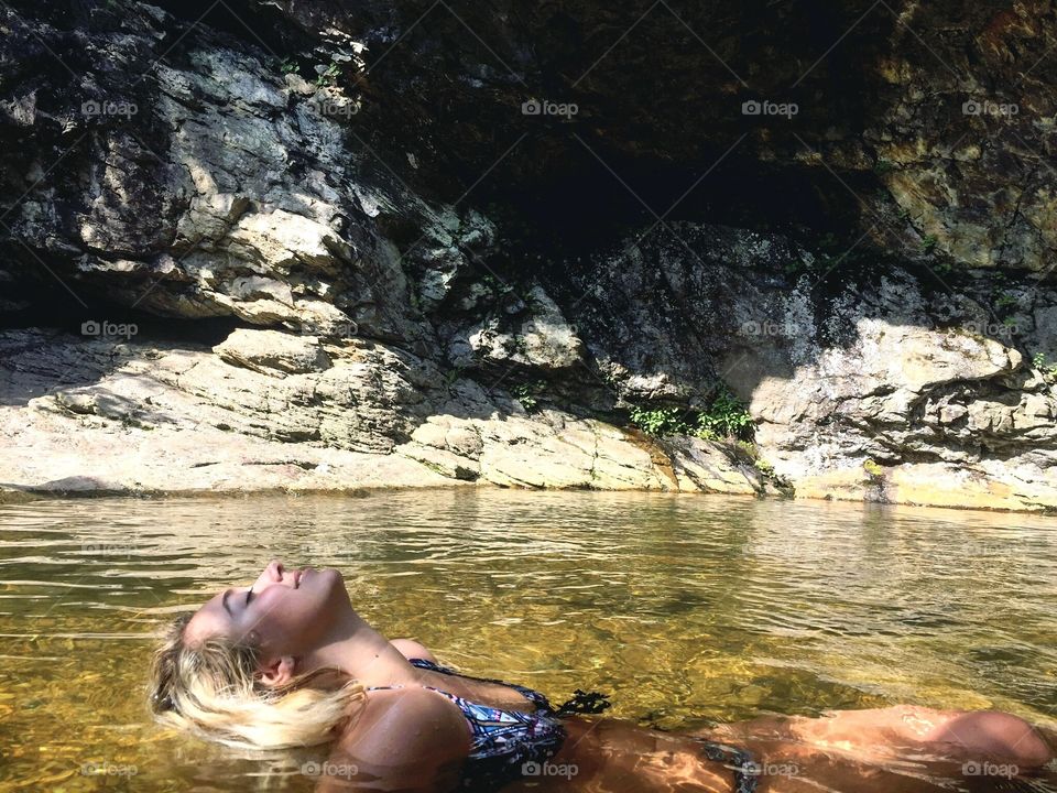 Girl in bikini in water at water fall. Location is a famous hiker favorite.