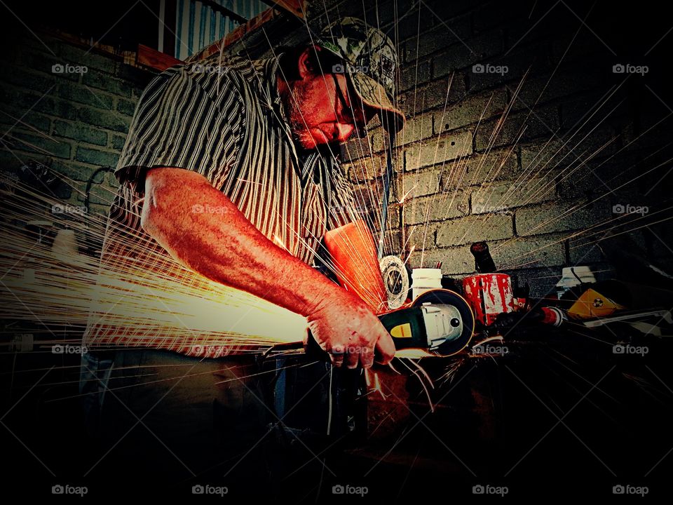 Industrial worker cutting metal with circular saw