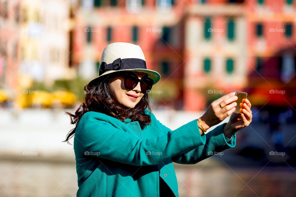 Smiling woman taking selfie on mobile phone