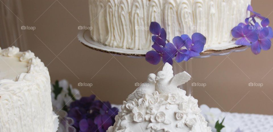 Spring wedding cake with love birds table decor and purple flowers