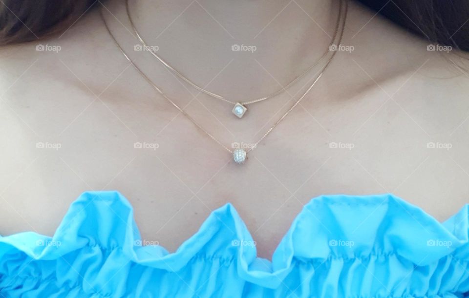 Shiny gold necklaces on the neck of woman. Close up