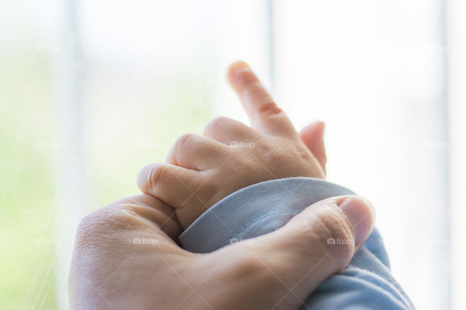 mother's hand holding a baby's hand