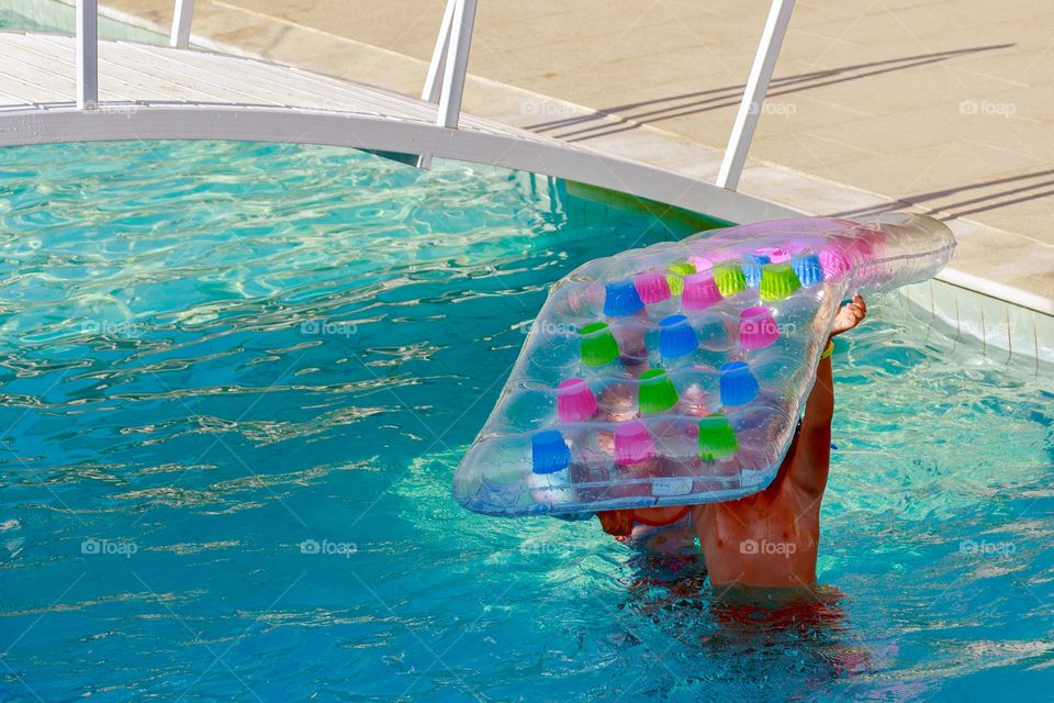 Children playing in the pool with inflatable float